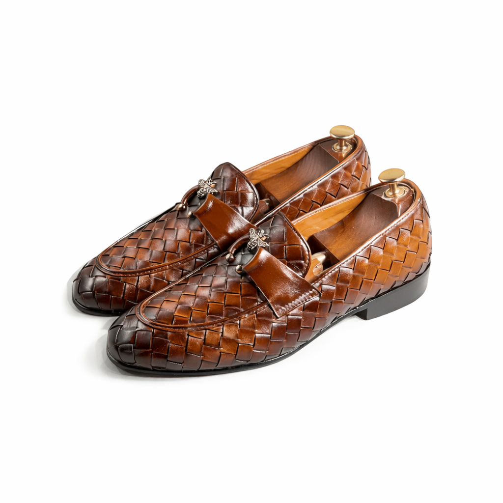 Pair of brown woven leather loafers on a white background