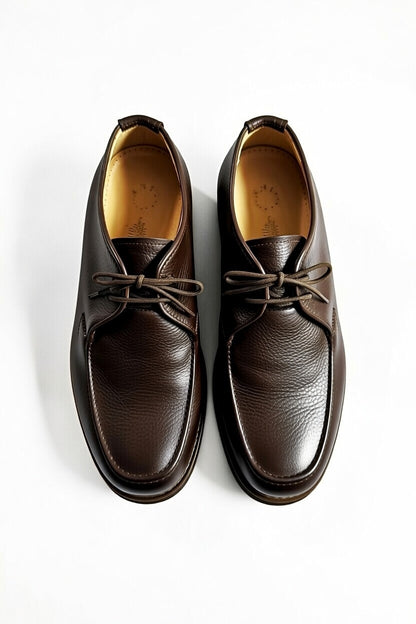 Men’s dark brown leather chukka shoes with lace-up design on white background