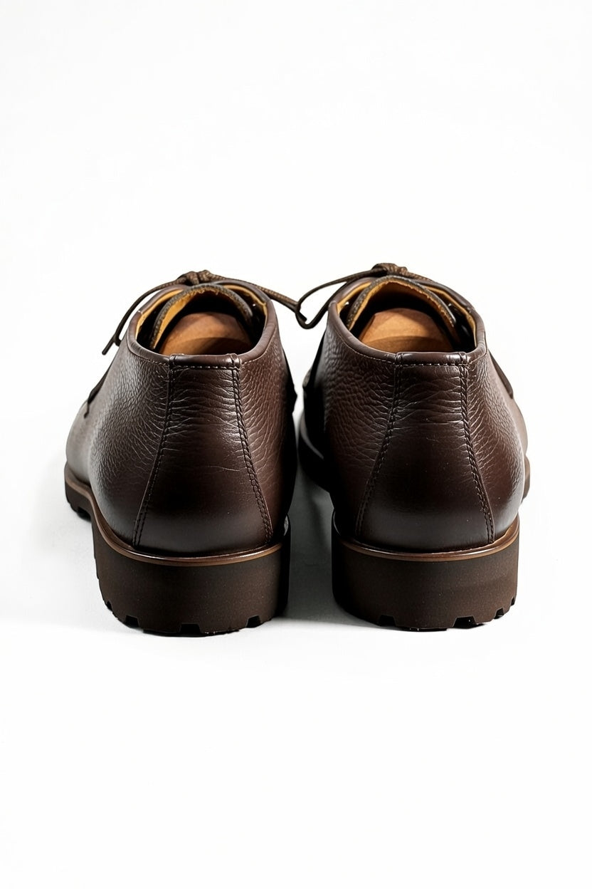 Men’s dark brown leather chukka shoes with lace-up design on white background