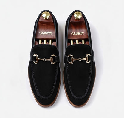 Men’s black leather horsebit loafers with gold buckle on white background