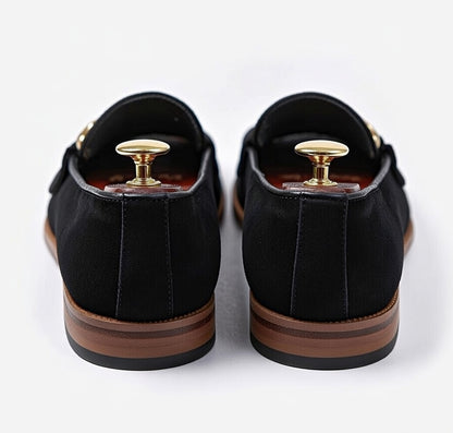 Men’s black leather horsebit loafers with gold buckle on white background