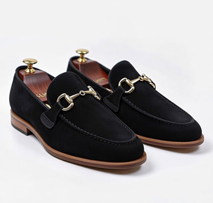 Men’s black leather horsebit loafers with gold buckle on white background