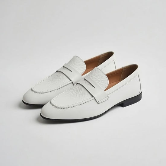Men’s white leather loafers with minimalist slip-on design on white background