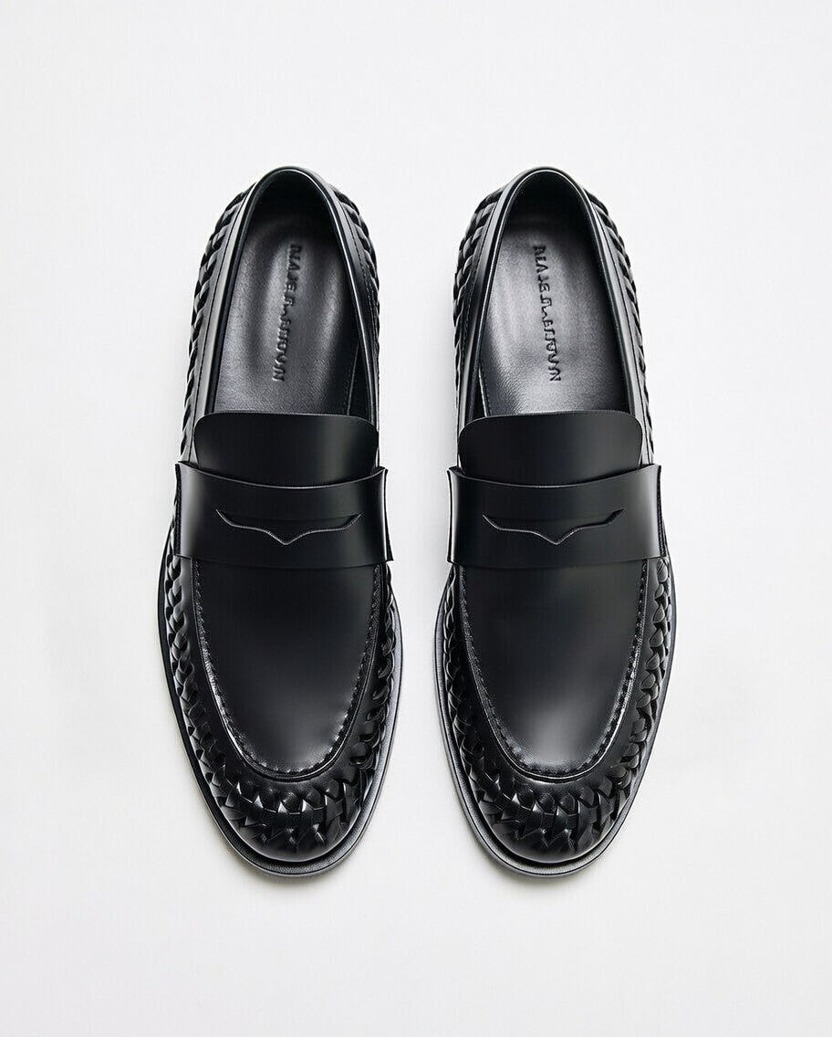 Black loafers with woven design on a white background