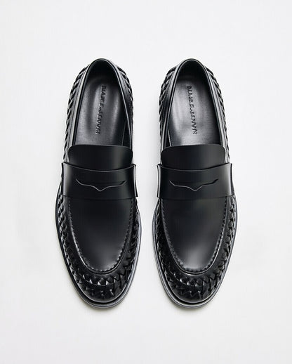 Black loafers with woven design on a white background
