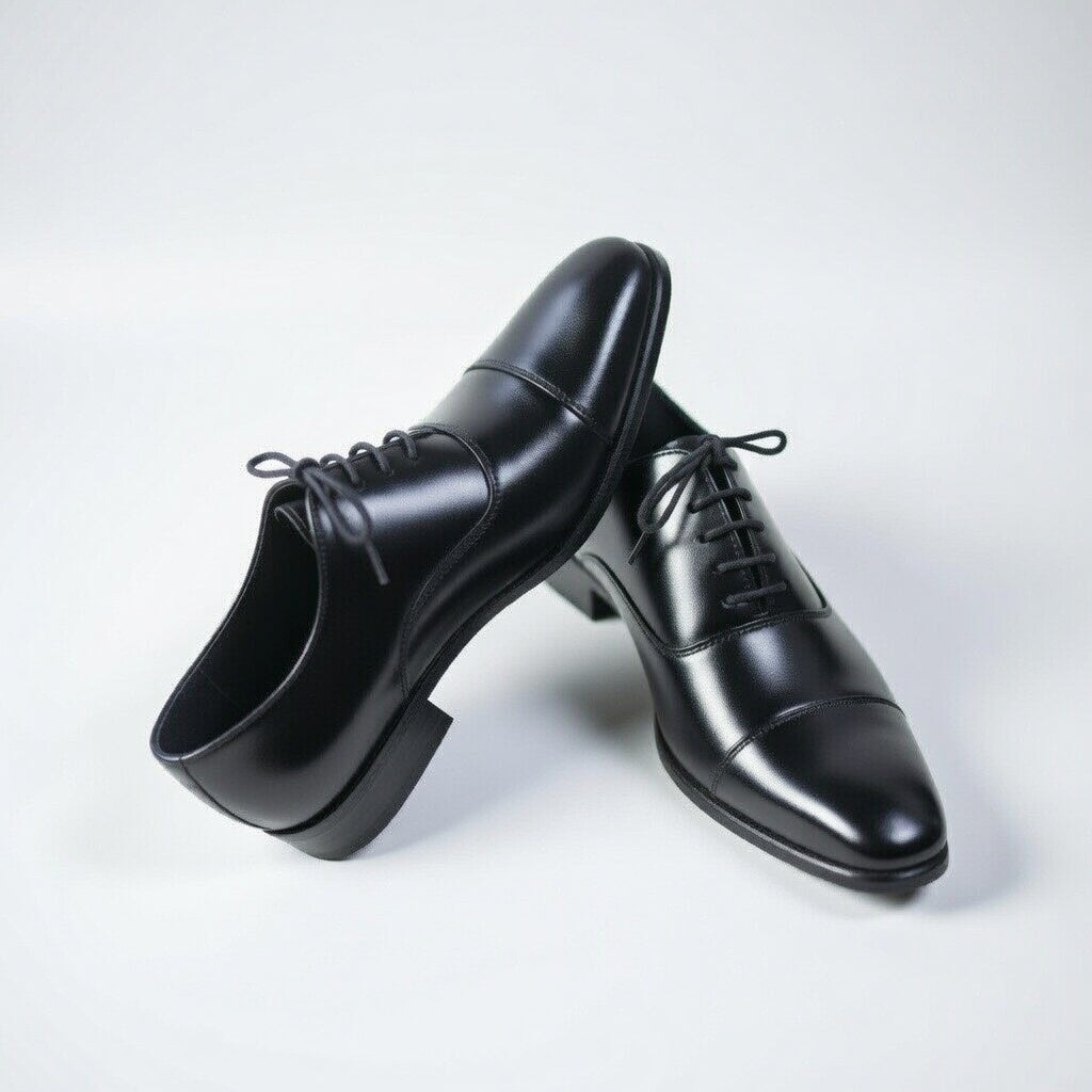 Pair of black dress shoes on a light gray background
