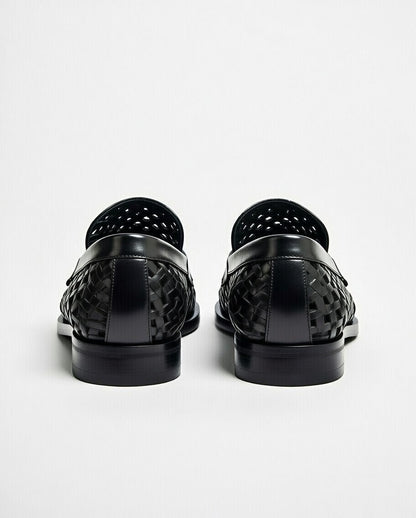 Black woven loafers on a white background