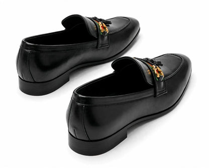 A pair of black leather penny loafers with a gold-tone horsebit detail on the strap, displayed on a clean white background.