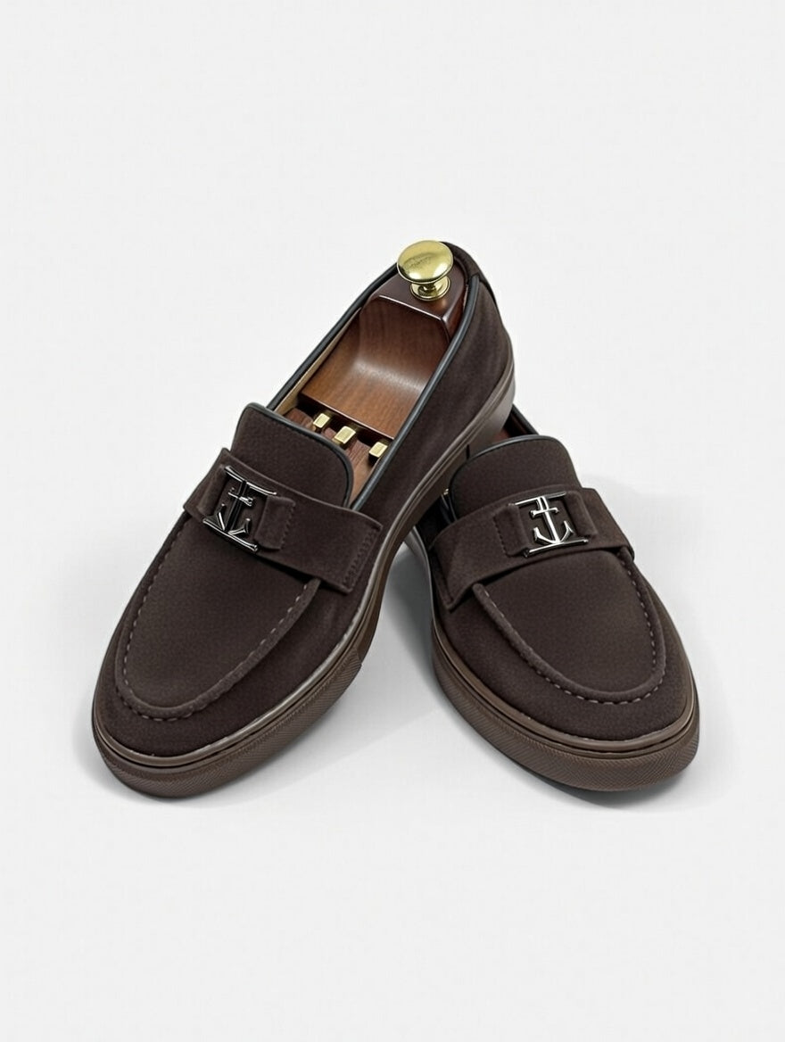 Pair of brown loafers with metal buckles on a white background