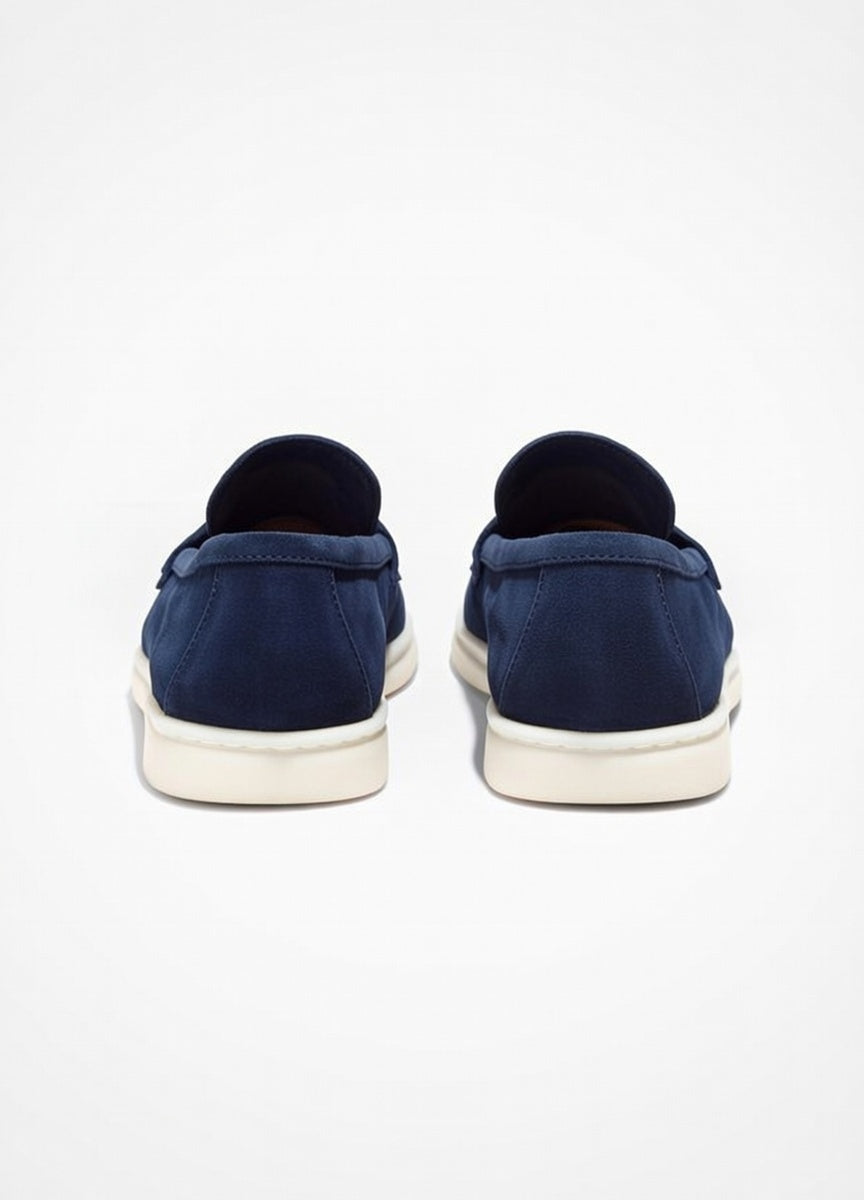 Navy slip-on shoes with white soles on a light gray background