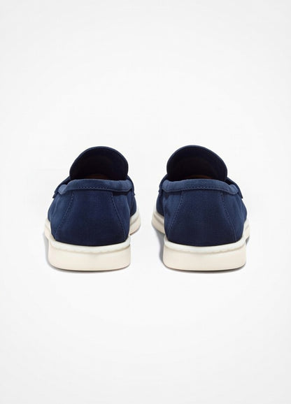 Navy slip-on shoes with white soles on a light gray background