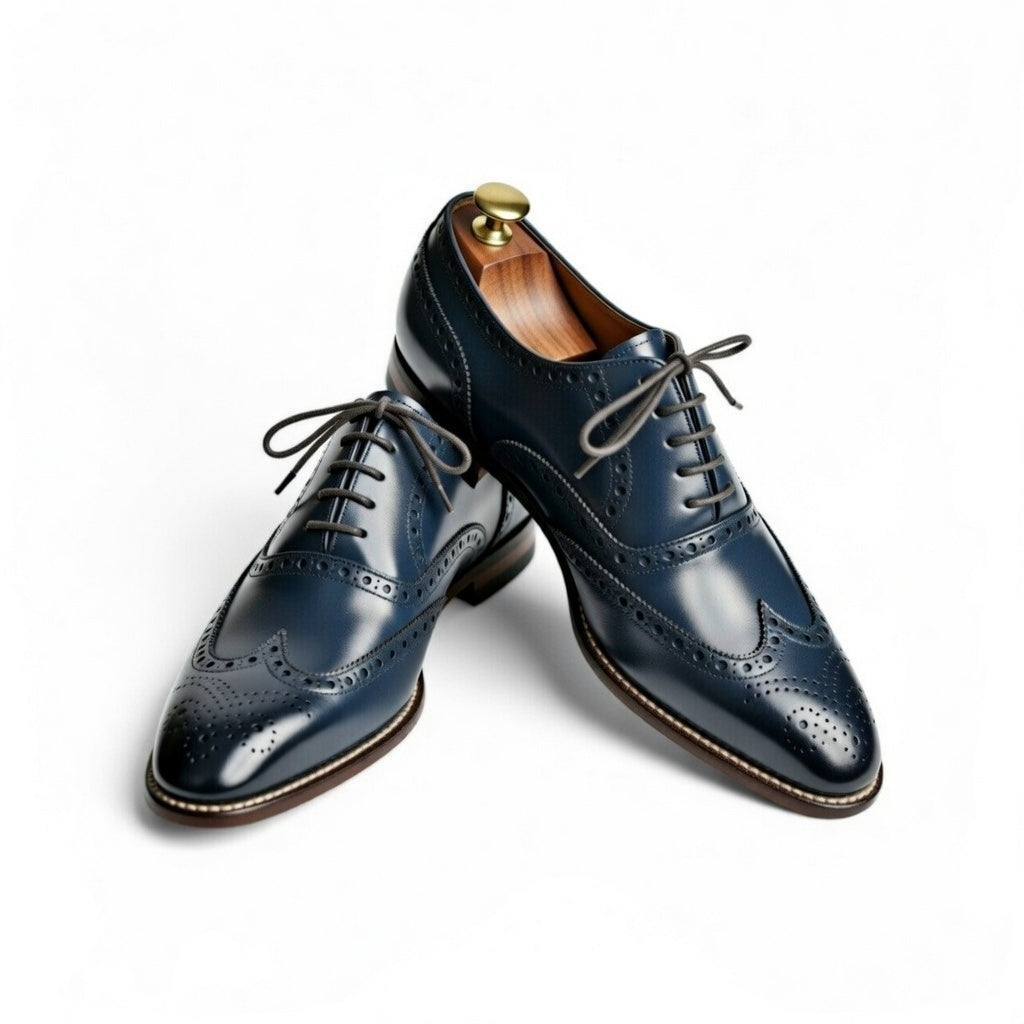 Pair of navy blue leather dress shoes on a white background
