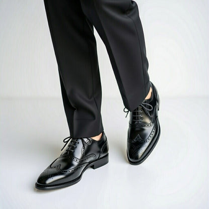 Black dress shoes and pants on a white background