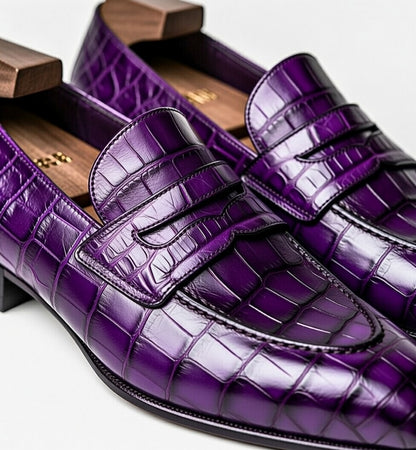 Purple crocodile-patterned loafers on a white background