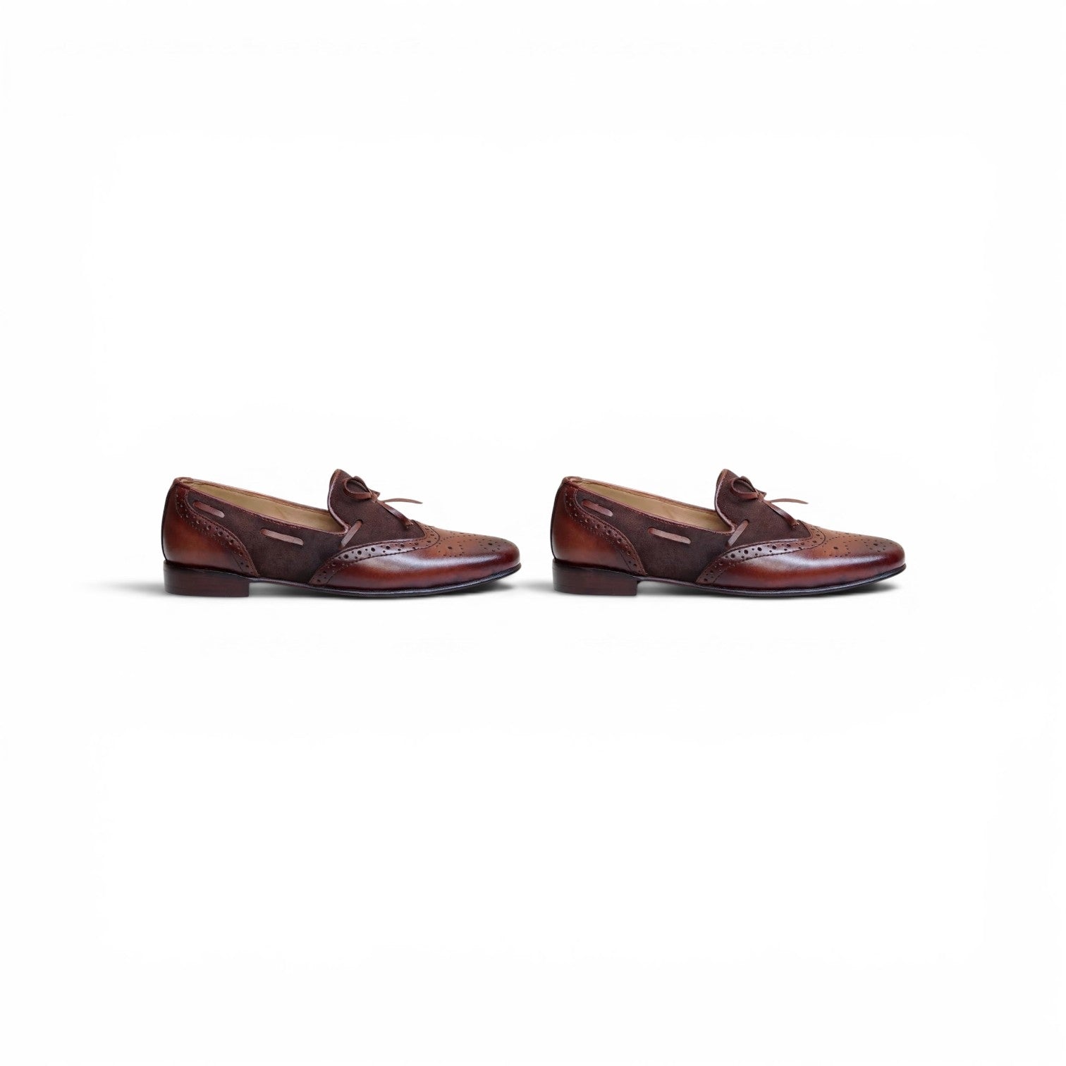 A pair of men's brown leather penny loafers with brogue detailing and a small leather tie, shown from the side on a plain white background.
