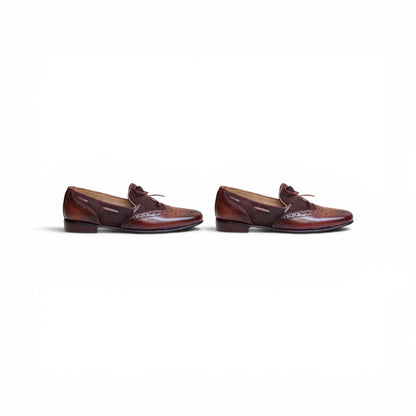 A pair of men's brown leather penny loafers with brogue detailing and a small leather tie, shown from the side on a plain white background.