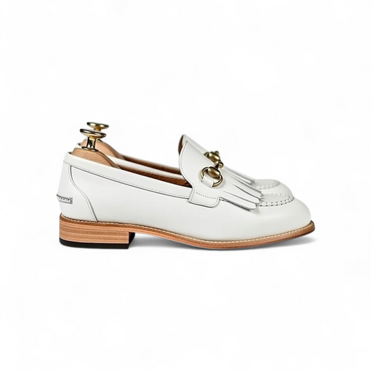 White loafer shoe with gold buckle on a white background