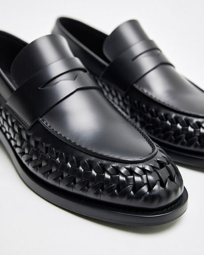 Black woven loafers on a white background