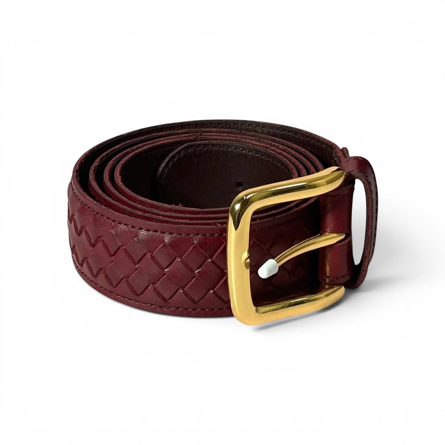 A dark burgundy woven leather belt with a polished gold buckle, coiled on a white background.