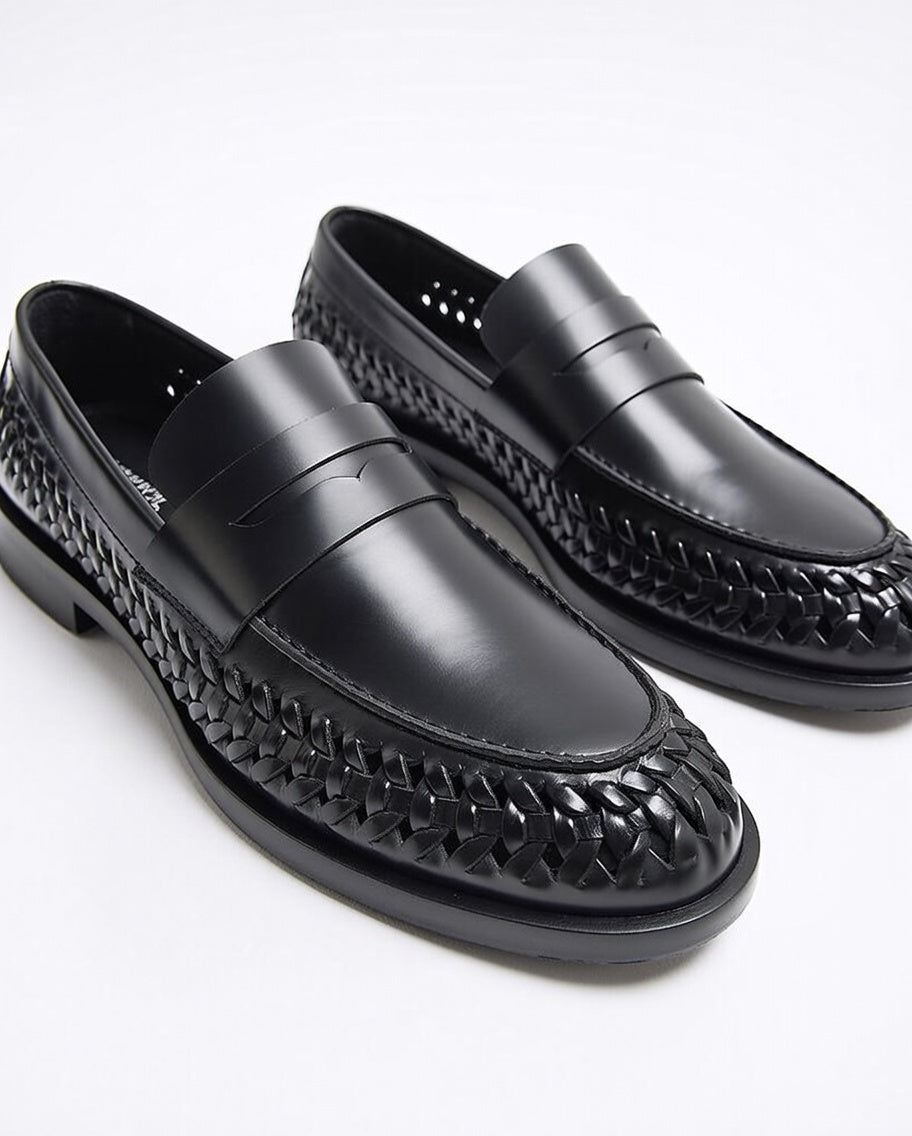 Black loafers with woven pattern on a white background