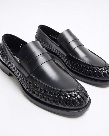 Black loafers with woven pattern on a white background