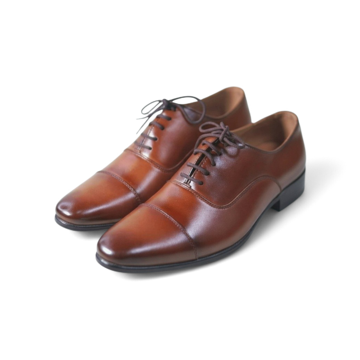 Pair of brown leather dress shoes on a white background