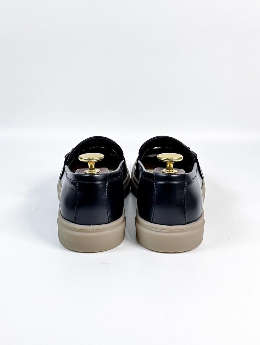 Black sneakers with beige soles on a white background
