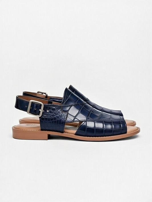 Navy blue sandals with brown soles on a light gray background