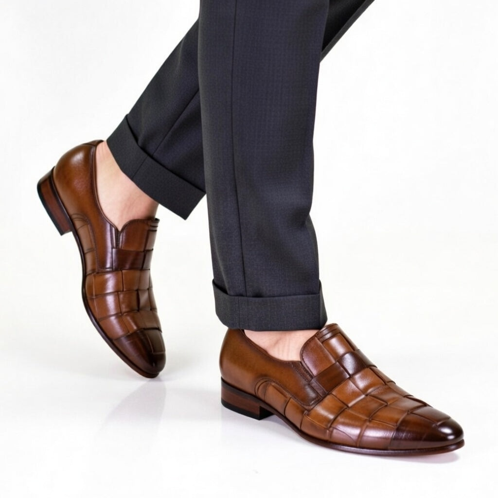 Brown leather shoes worn with black pants on a white background