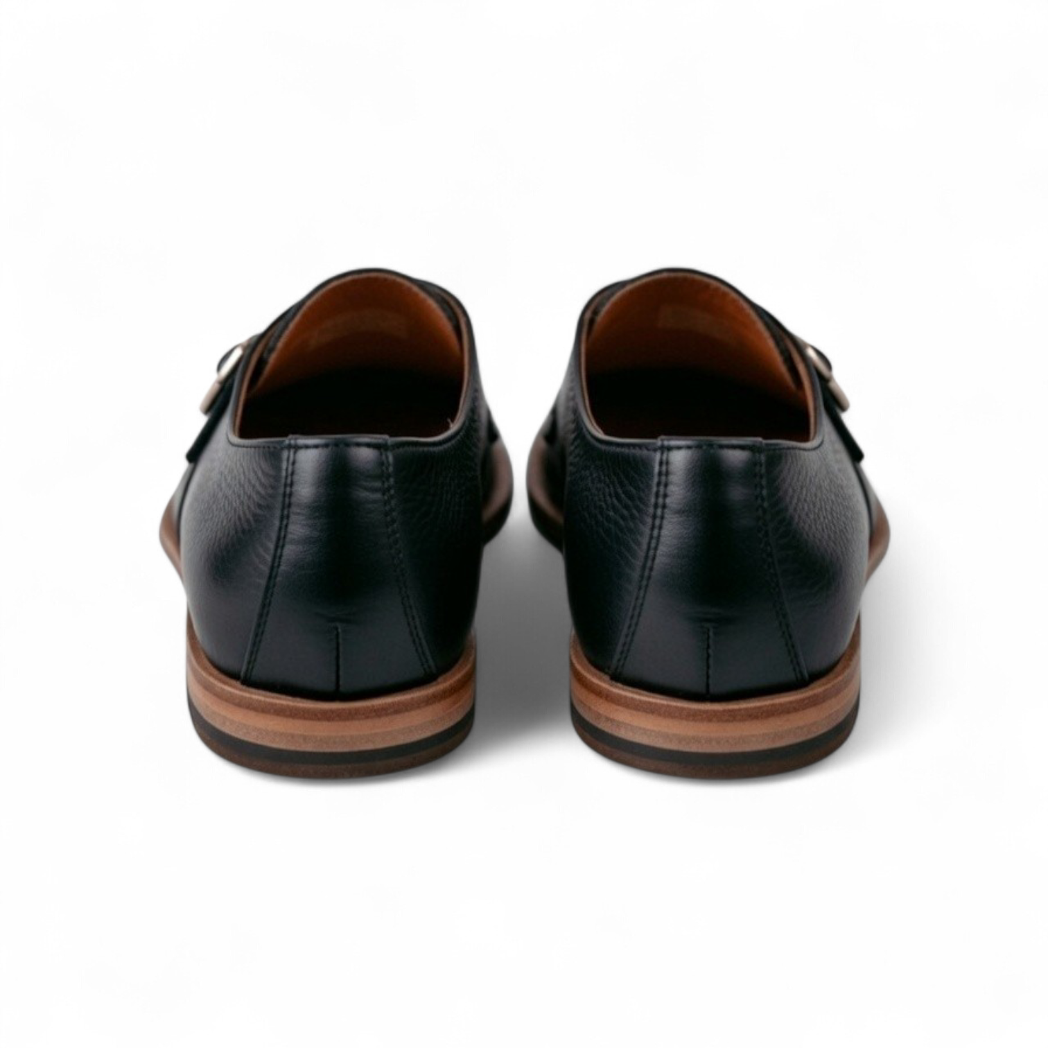 Black leather shoes with brown soles on a white background