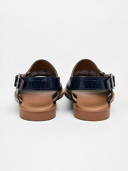 Pair of black sandals with brown soles on a white background