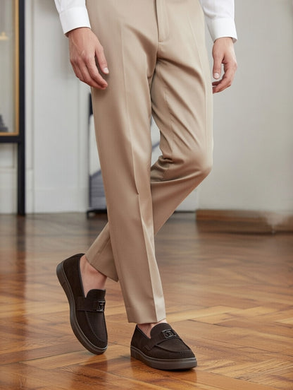Person wearing beige pants and brown loafers on a wooden floor.