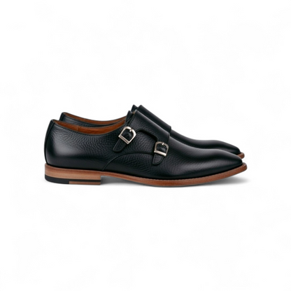 Black leather shoes with brown soles on a white background