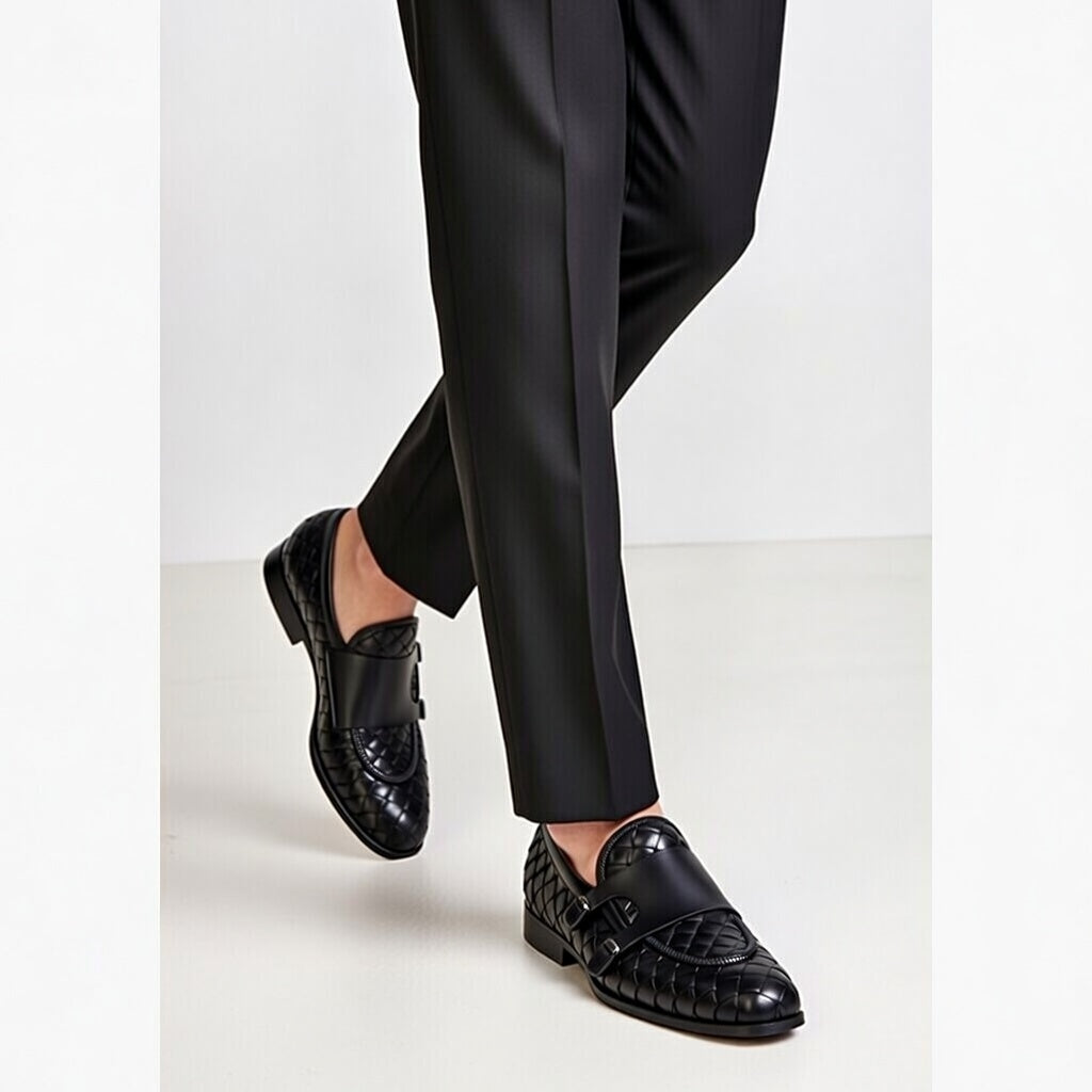 Black loafers worn with black pants on a white background