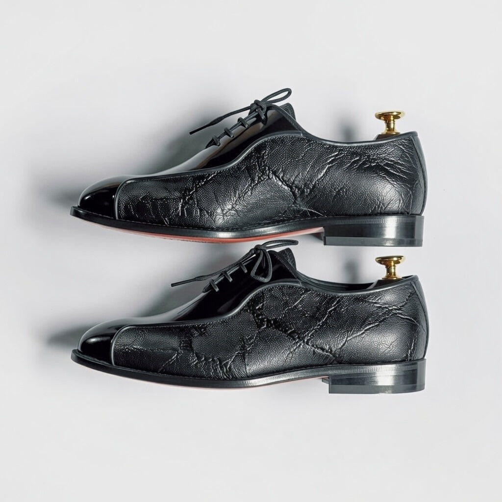 Pair of black leather dress shoes on a white background