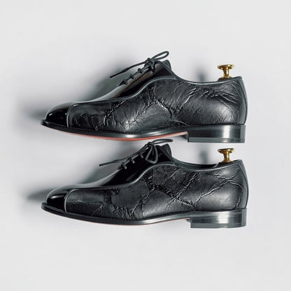 Pair of black leather dress shoes on a white background