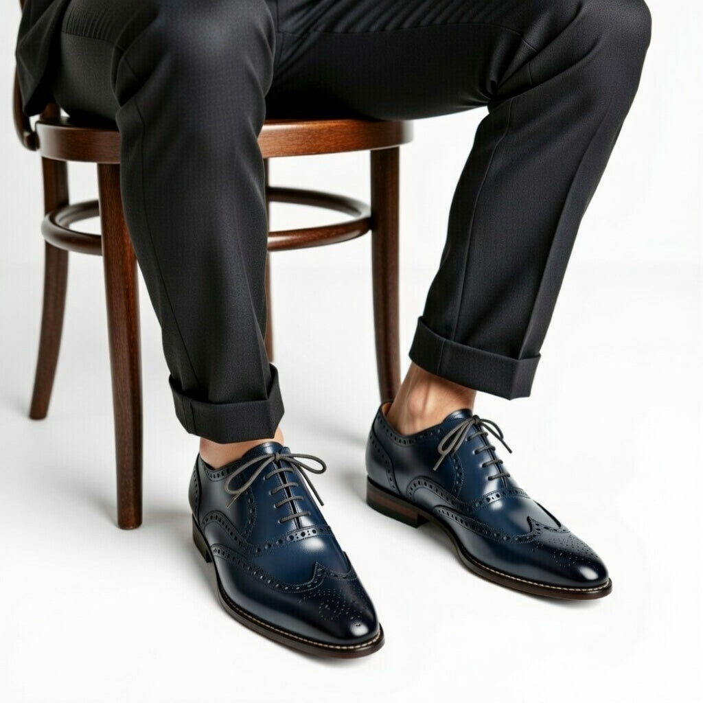 Person wearing dark blue dress shoes with a white background