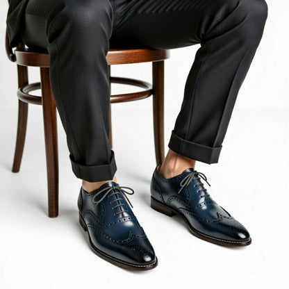 Person wearing dark blue dress shoes with a white background