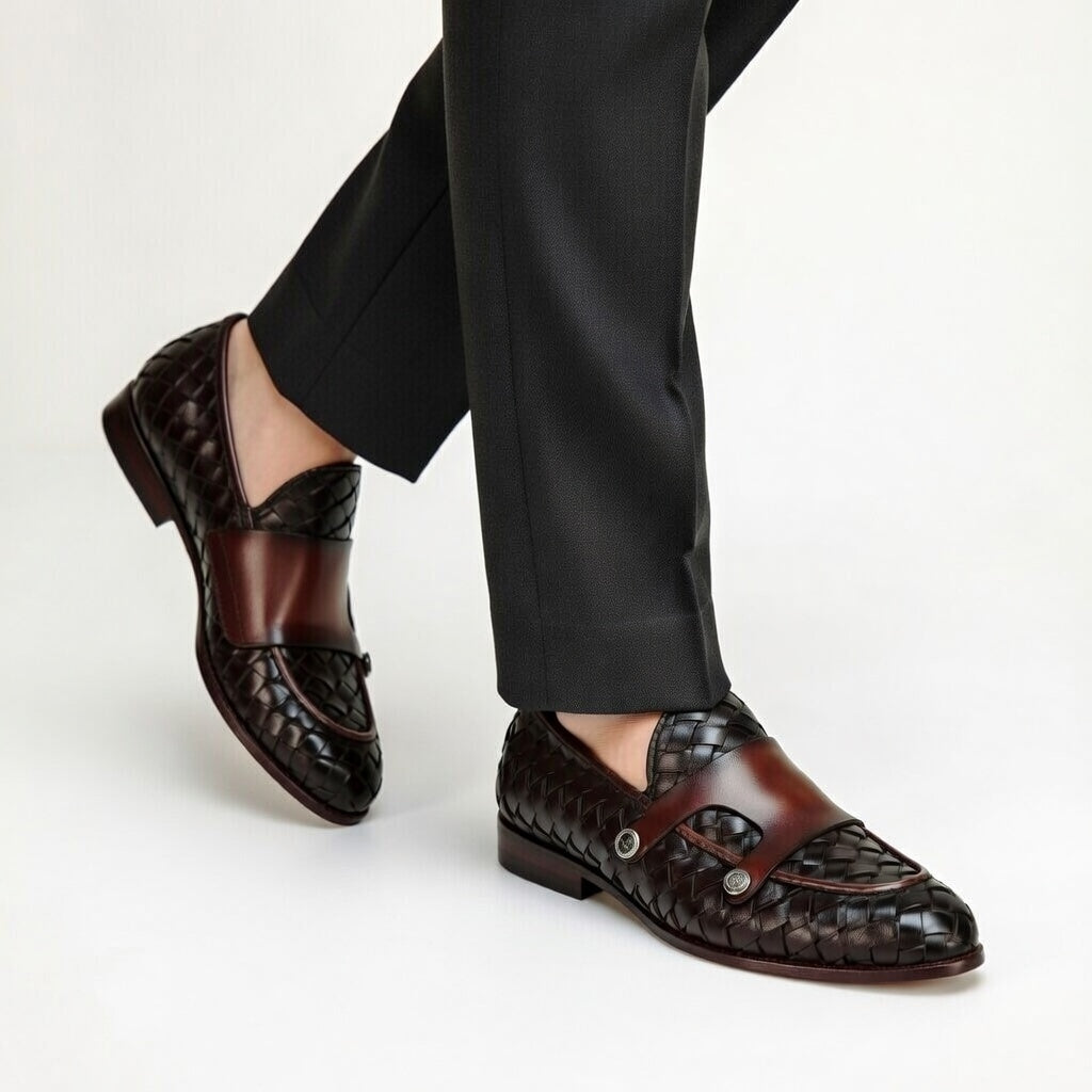 Brown woven loafers worn with black pants on a white background