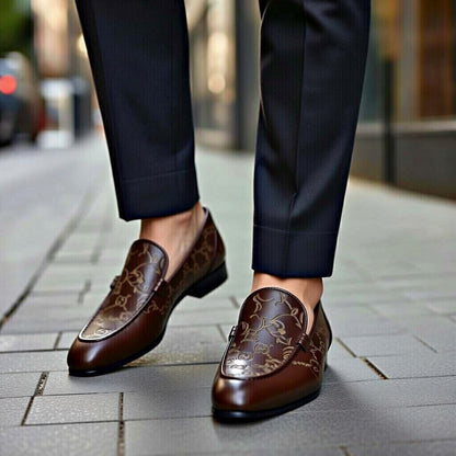 Brown loafers with intricate design worn on a city street.