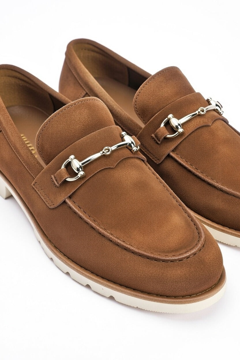 Brown loafers with silver buckles on a white background