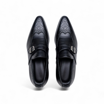 Pair of black dress shoes with decorative patterns on a white background