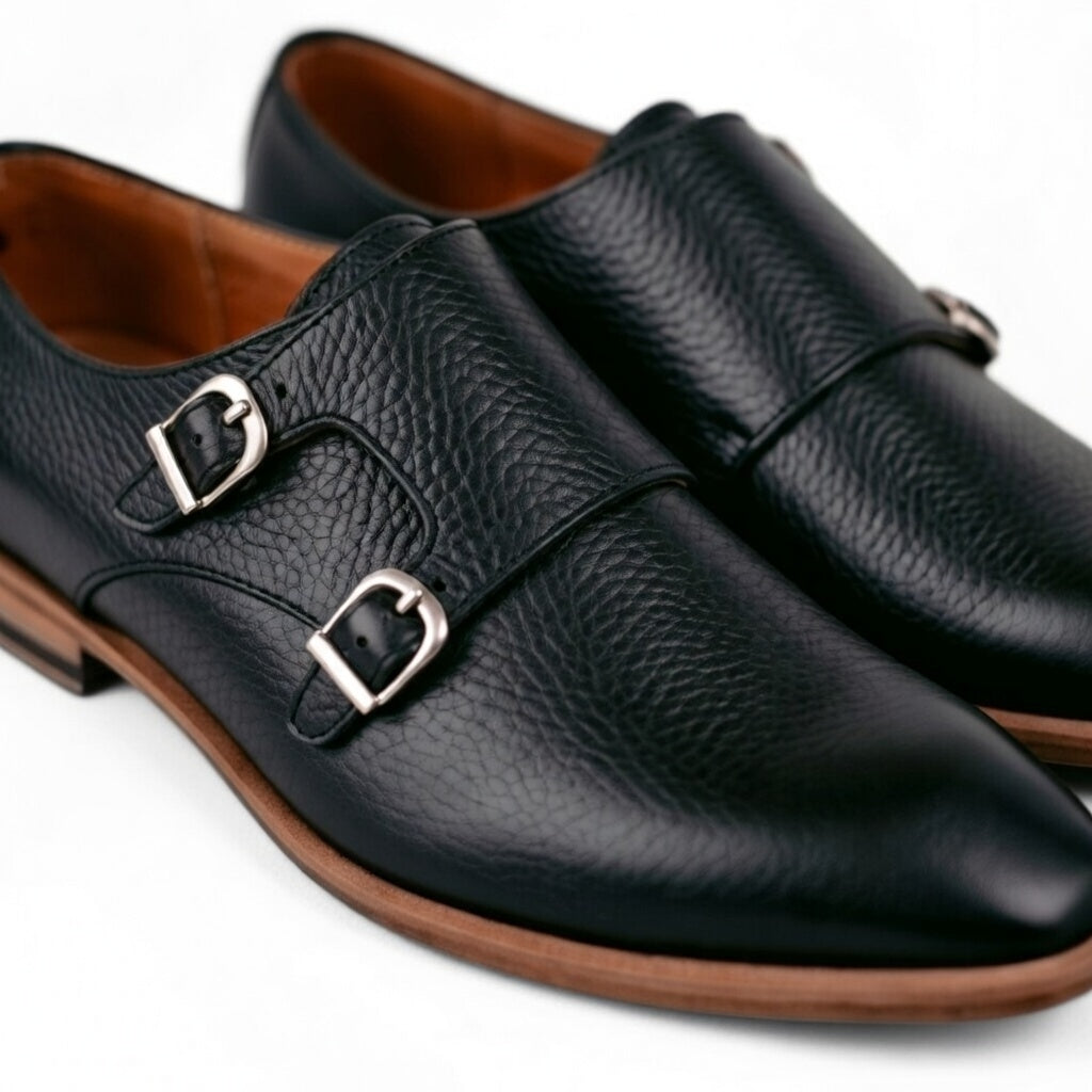 Pair of black leather shoes with buckles on a white background