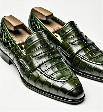 Green crocodile-patterned loafers on a white background