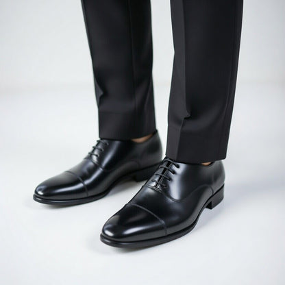 Black dress shoes and black pants on a white background