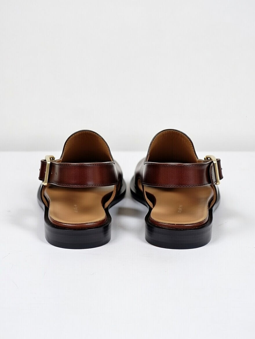 Pair of brown sandals with black soles on a white background
