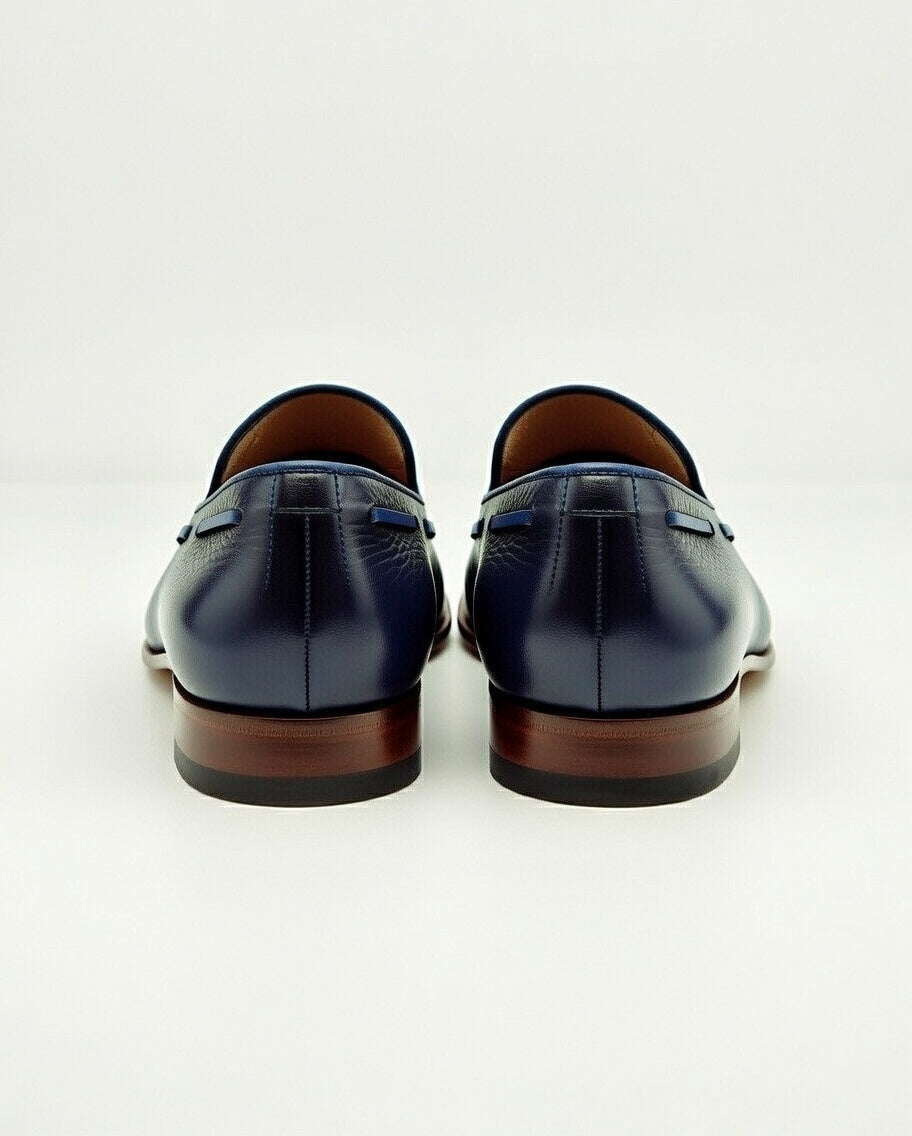 Pair of navy blue leather loafers on a white background