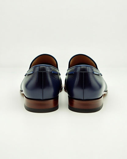 Pair of navy blue leather loafers on a white background