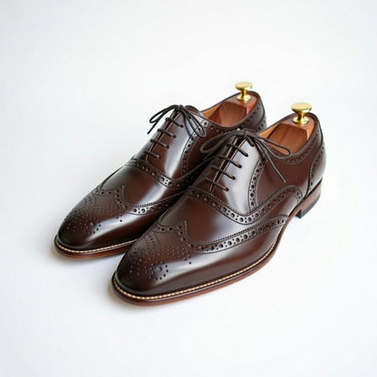 Pair of brown leather dress shoes on a white background