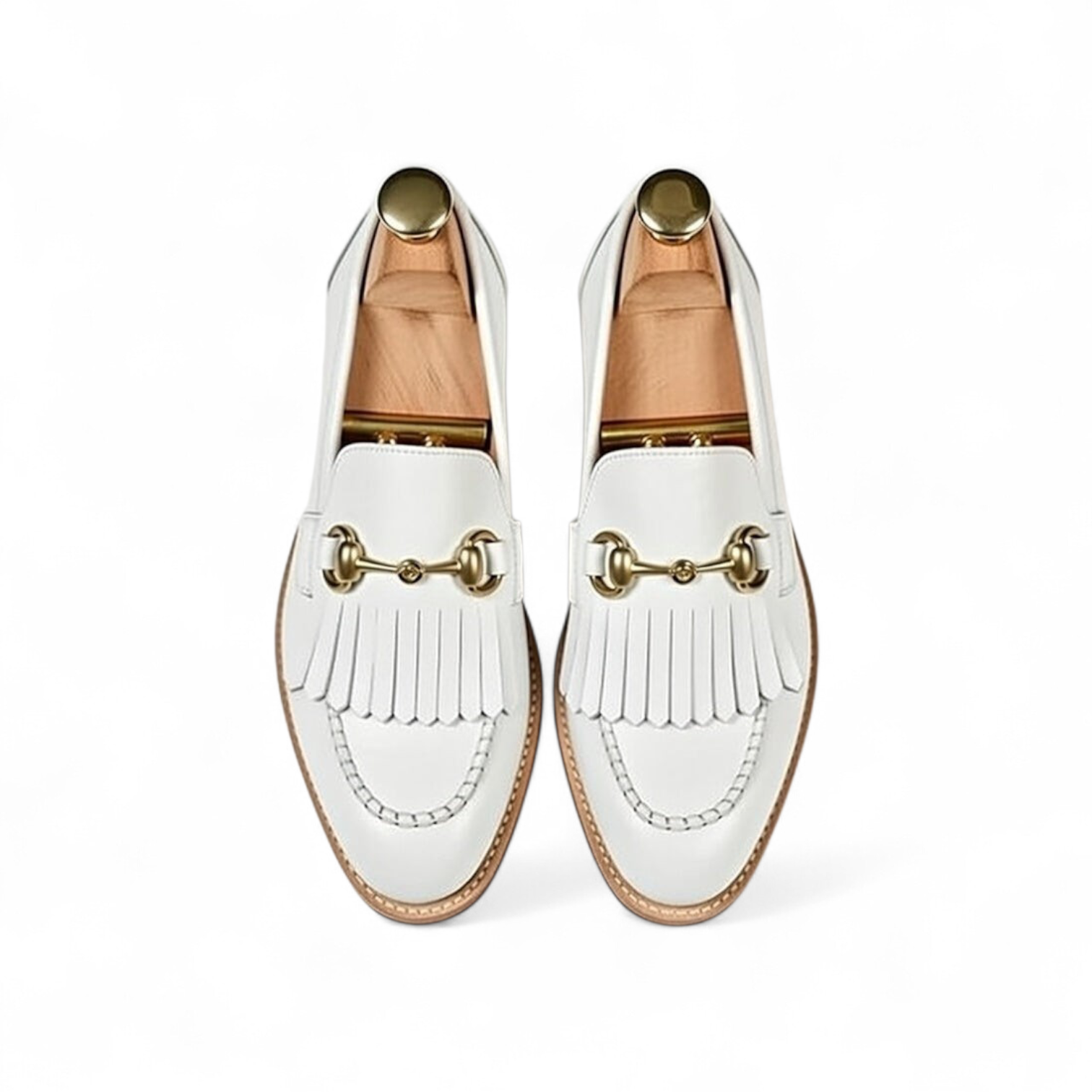 White loafers with gold accents on a white background